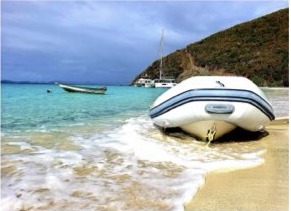 Dinghy pulled up onto a quiet beach