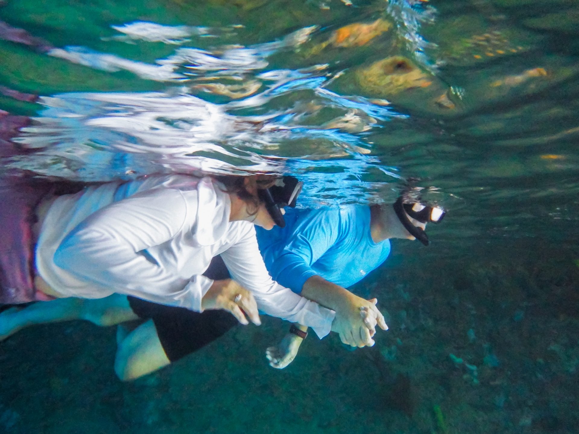 Couple snorkeling together holding hands